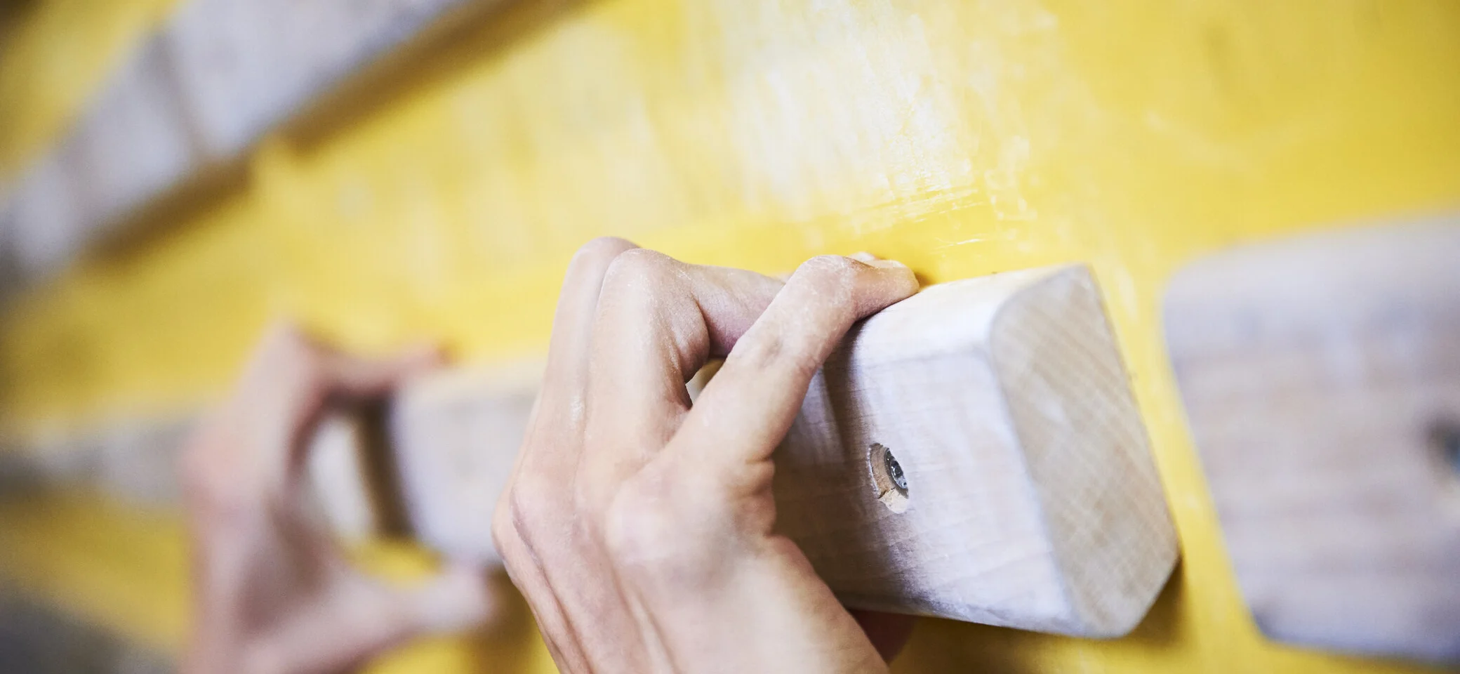DAV Kletterhalle | © DAV/Frank Kretschmann Hände greifen nach Holzelementen an einer Kletterwand | © DAV/Frank Kretschmann